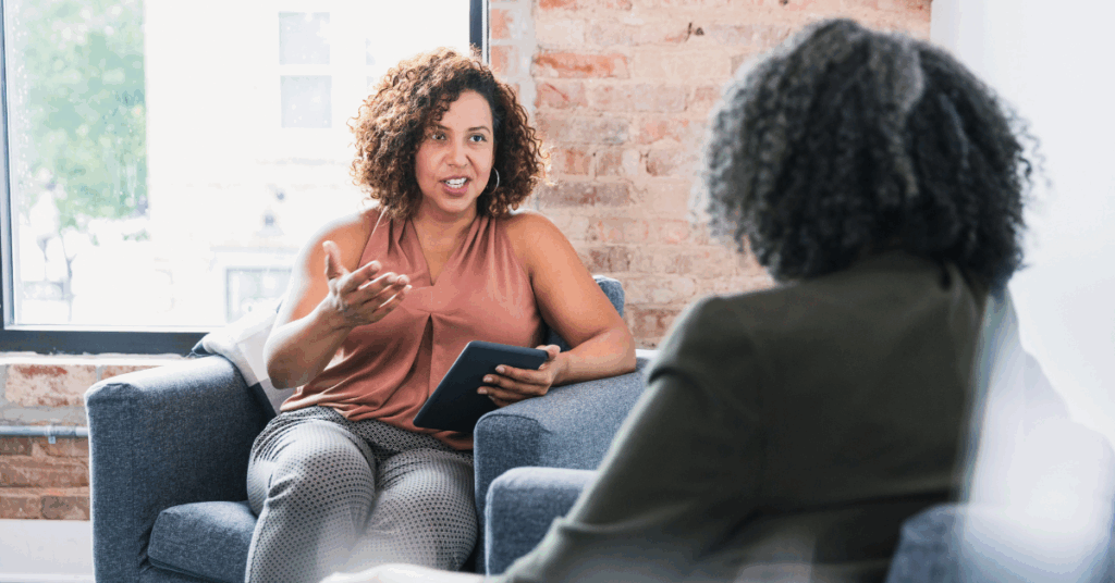Therapist offering compassionate support to a client in a calm, inviting counseling space