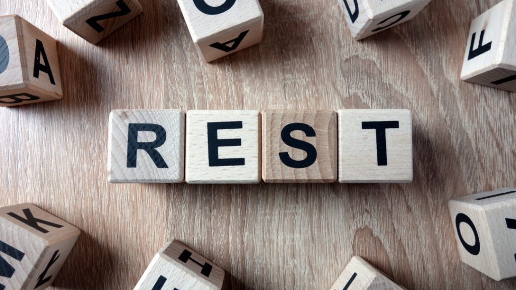 Recovering from Chronic Stress: Rebuilding Emotional and Physical Balance - Wooden letter blocks spell 'REST' on a wooden table, with scattered alphabet blocks around them.
